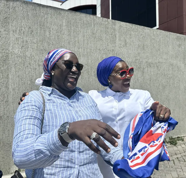 Two attendees posing together with an NPP flag